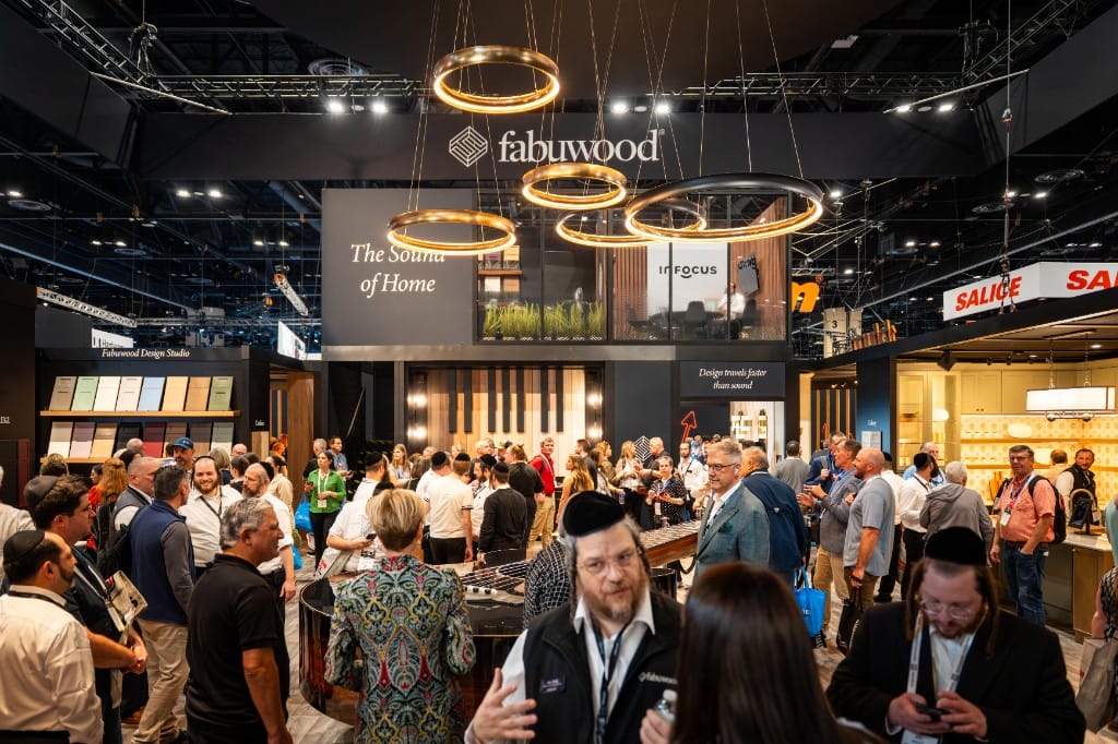 A crowded Fabuwood booth at KBIS with The Sound of Home display, ring chandeliers, and attendees throughout the show floor.